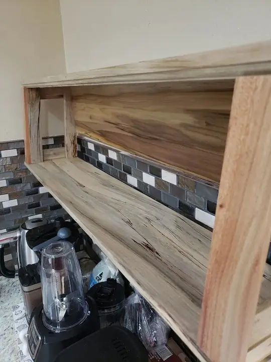 Open wooden shelves against a kitchen backsplash